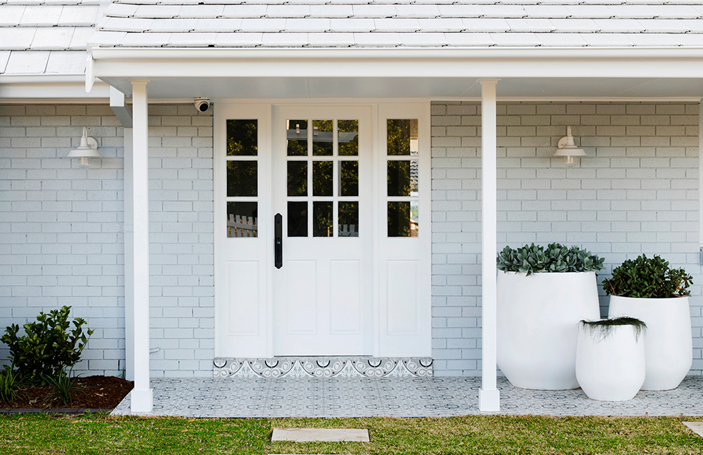 Pale grey house with a luxurious white front door, including sidelights.